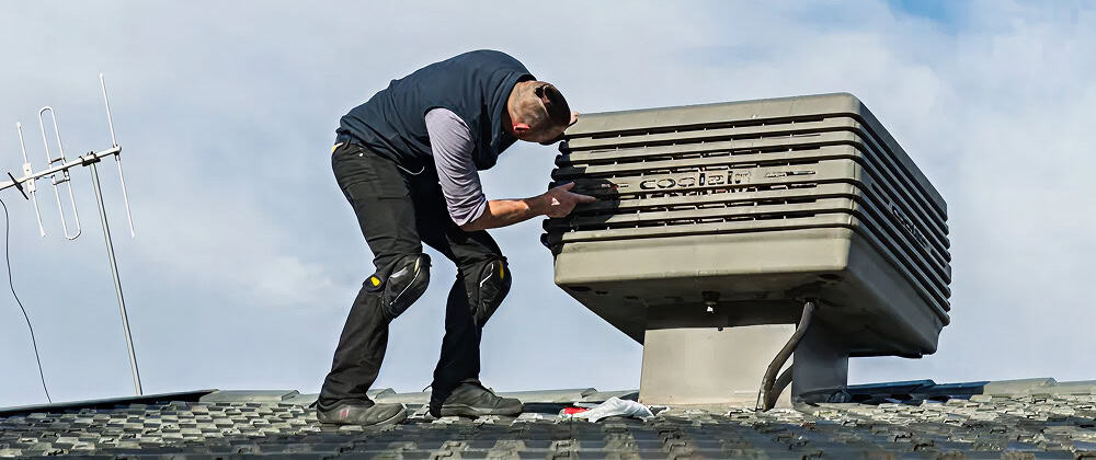 Technician servicing evaporative cooler in Canberra for optimal cooling performance.